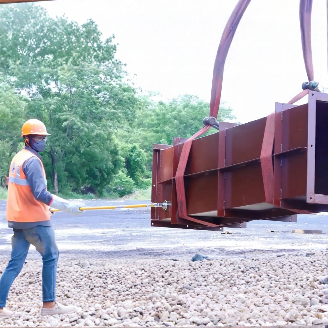 Worker using a PSC long-reach tool to control a suspended load